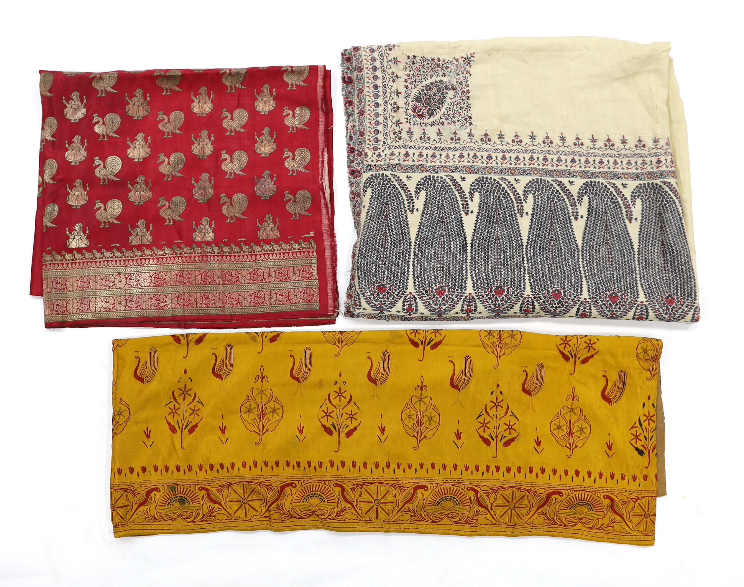 A 19th century fine cream woven Kashmiri shawl with blue and red teardrop design borders, an early 20th century gold satin pelmet with spot motifs of peacocks and flowers, 204cm long x 71cm high and a length of silk with